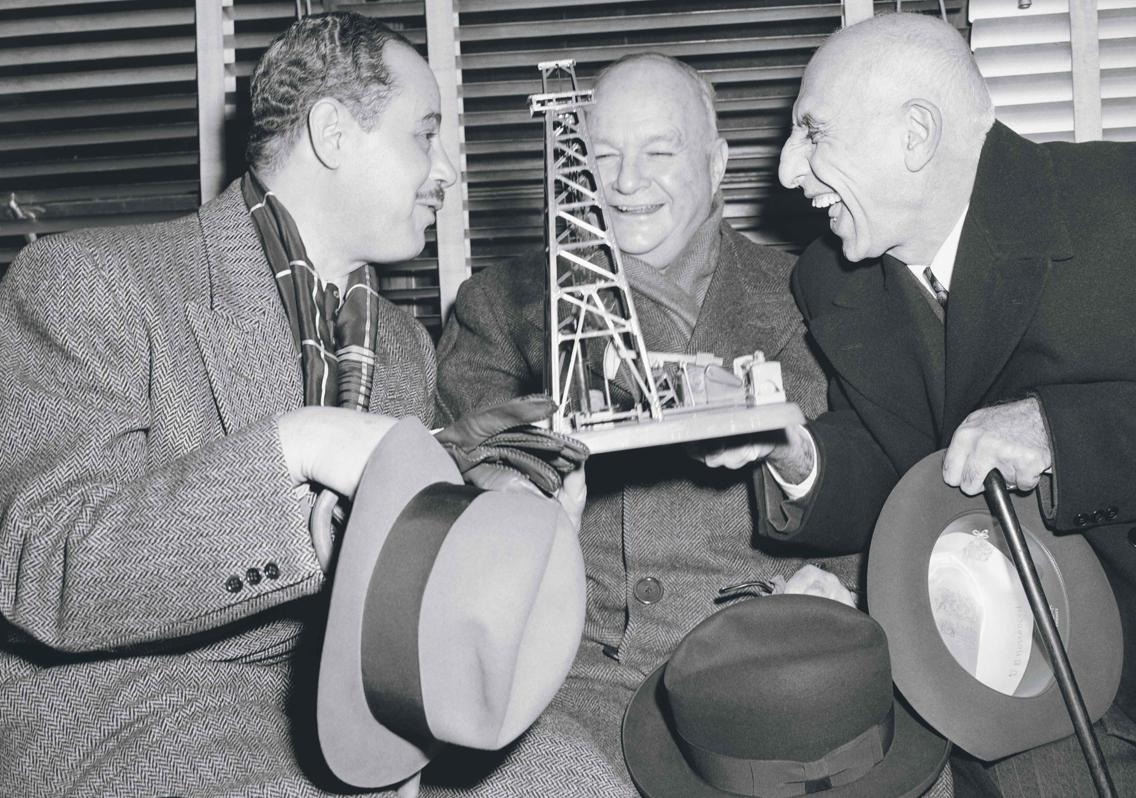 Mosaddeq (dcha.) bromea con el embajador norteamericano en Irán y un abogado que le regaló una miniatura de un pozo petrolífero. Era 1951 y el iraní aún creía que llegaría a un acuerdo con ellos y los británicos.