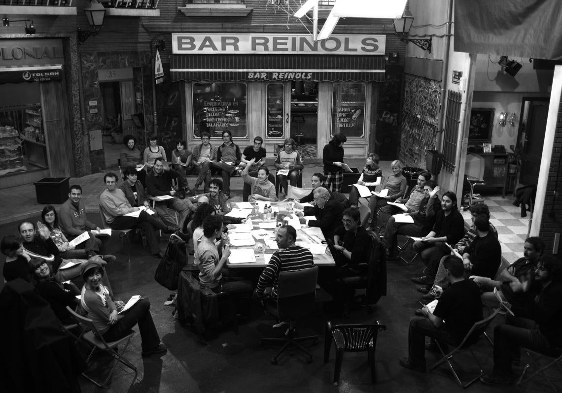 El equipo de Aída (Velilla, de espaldas, preside la mesa, con Carmen Machi al otro extremo) durante la lectura de guion (italiana, en argot cinematográfico), previa al ensayo y rodaje de un capítulo de la serie.