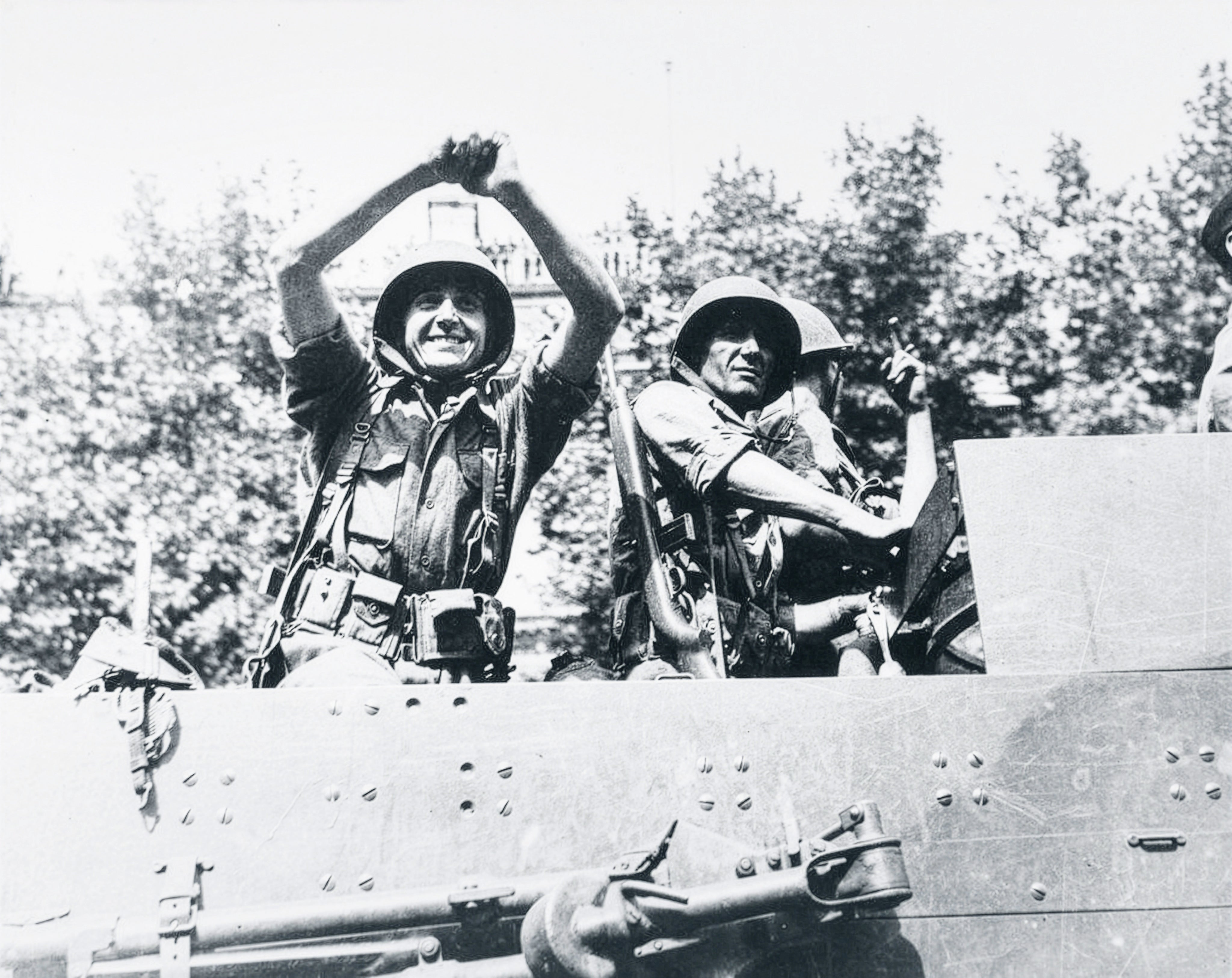 Imagen secundaria 2 - De arriba a abajo, un parisino de la Resistencia saluda a los españoles del Brunete tras tomar la capital francesa; el Guernica, con soldados de La Nueve, participa en el desfile triunfal de los aliados por los Campos Elíseos; un soldado español (se cree que Pablo Moraga), hace el saludo anarquista tras participar en la liberación de la capital francesa.