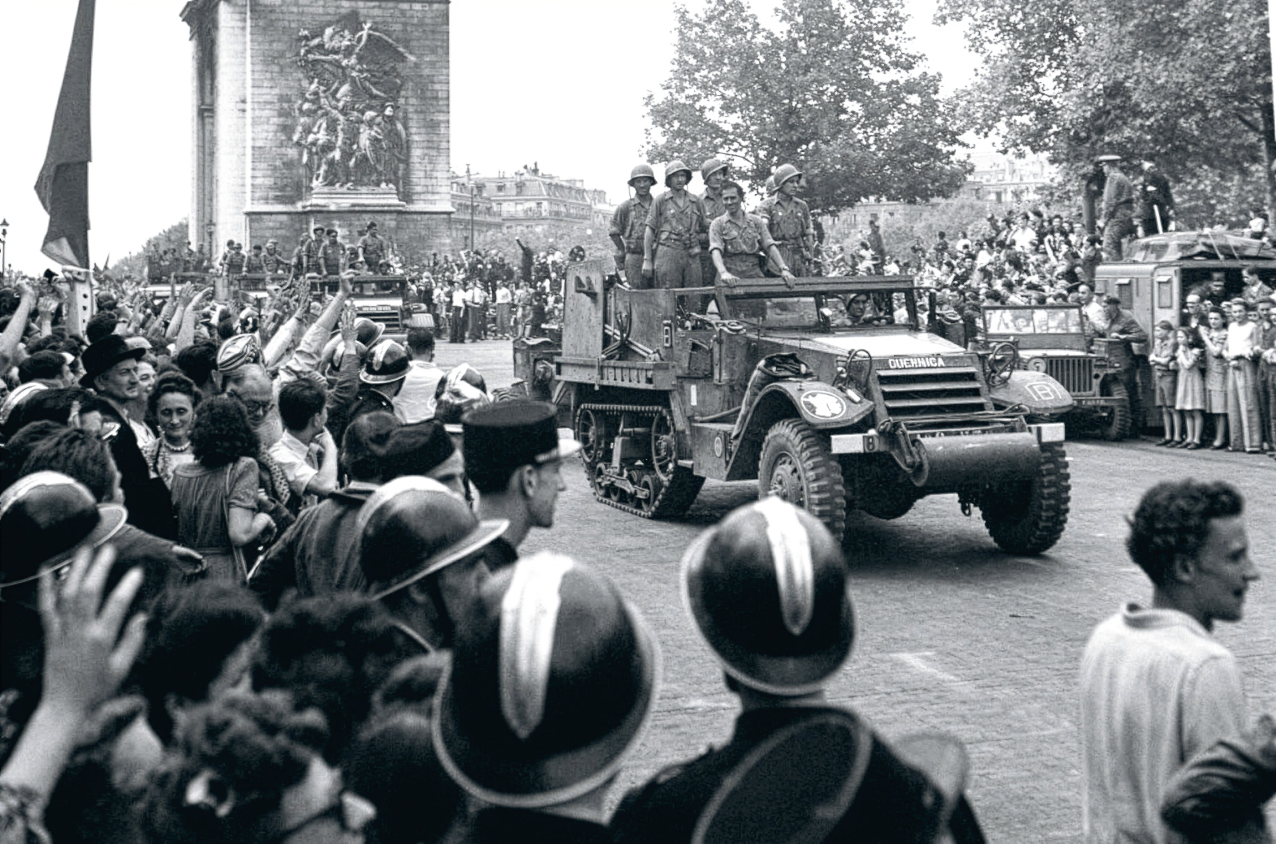 Imagen secundaria 1 - De arriba a abajo, un parisino de la Resistencia saluda a los españoles del Brunete tras tomar la capital francesa; el Guernica, con soldados de La Nueve, participa en el desfile triunfal de los aliados por los Campos Elíseos; un soldado español (se cree que Pablo Moraga), hace el saludo anarquista tras participar en la liberación de la capital francesa.