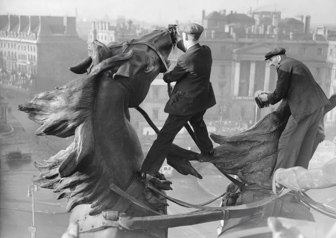 Dos empleados municipales limpian en 1939 (sin medidas protectoras) los caballos del conjunto escultórico conocido como La cuadriga, que corona el Arco de Wellington, en Londres.