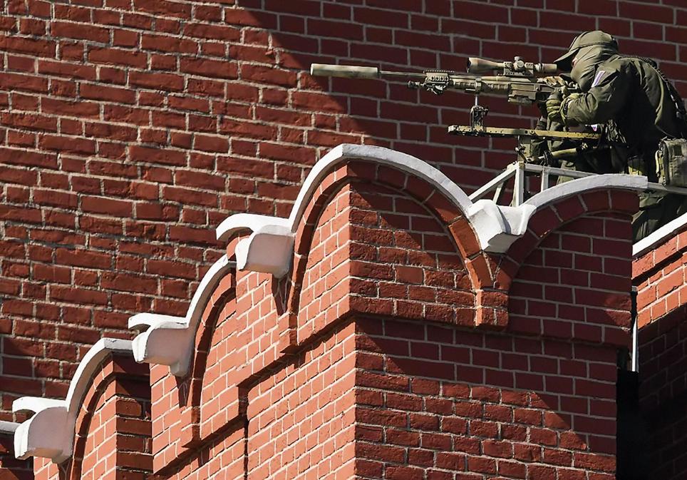Un francotirador armado con un rifle de alta precisión vigila un acto de Putin en Moscú.  