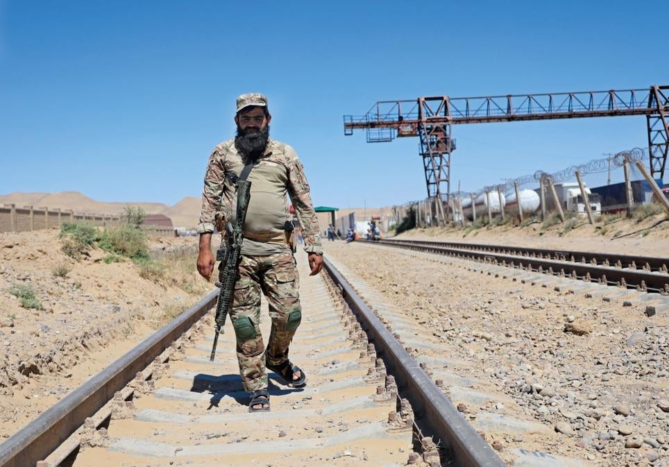 Un miembro del personal de seguridad talibán camina por las vías del tren en la inauguración del gasoducto entre Afganistán y Turkmenistán