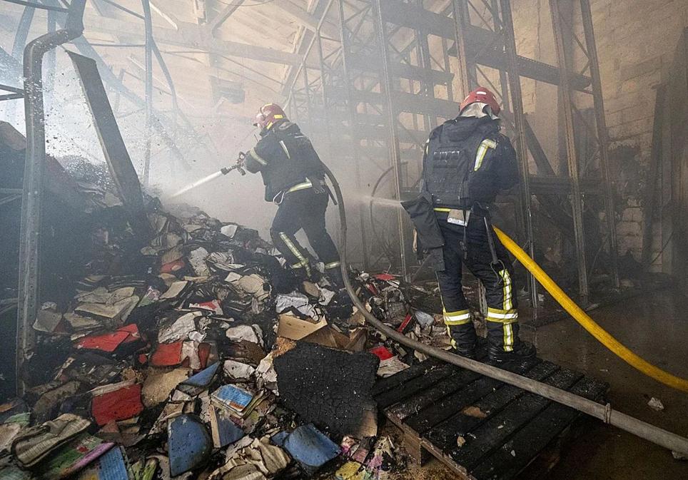 Bomberos ucranianos intentando apagar el fuego en la edtorial editorial Ranok, de Viktor Kruglov, en Kiev.