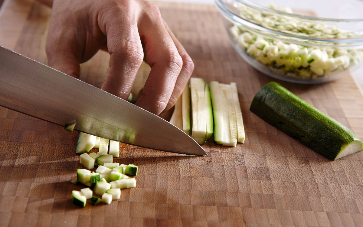 Para empezar con la receta de cogollos de lechuga al horno, se trocean las cebolletas, las zanahorias y el calabacín en dados de un tamaño similar