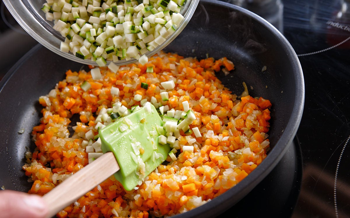 Se pochan las verduras en una sartén con aceite. Cuando estén listas, se añade el caldo.