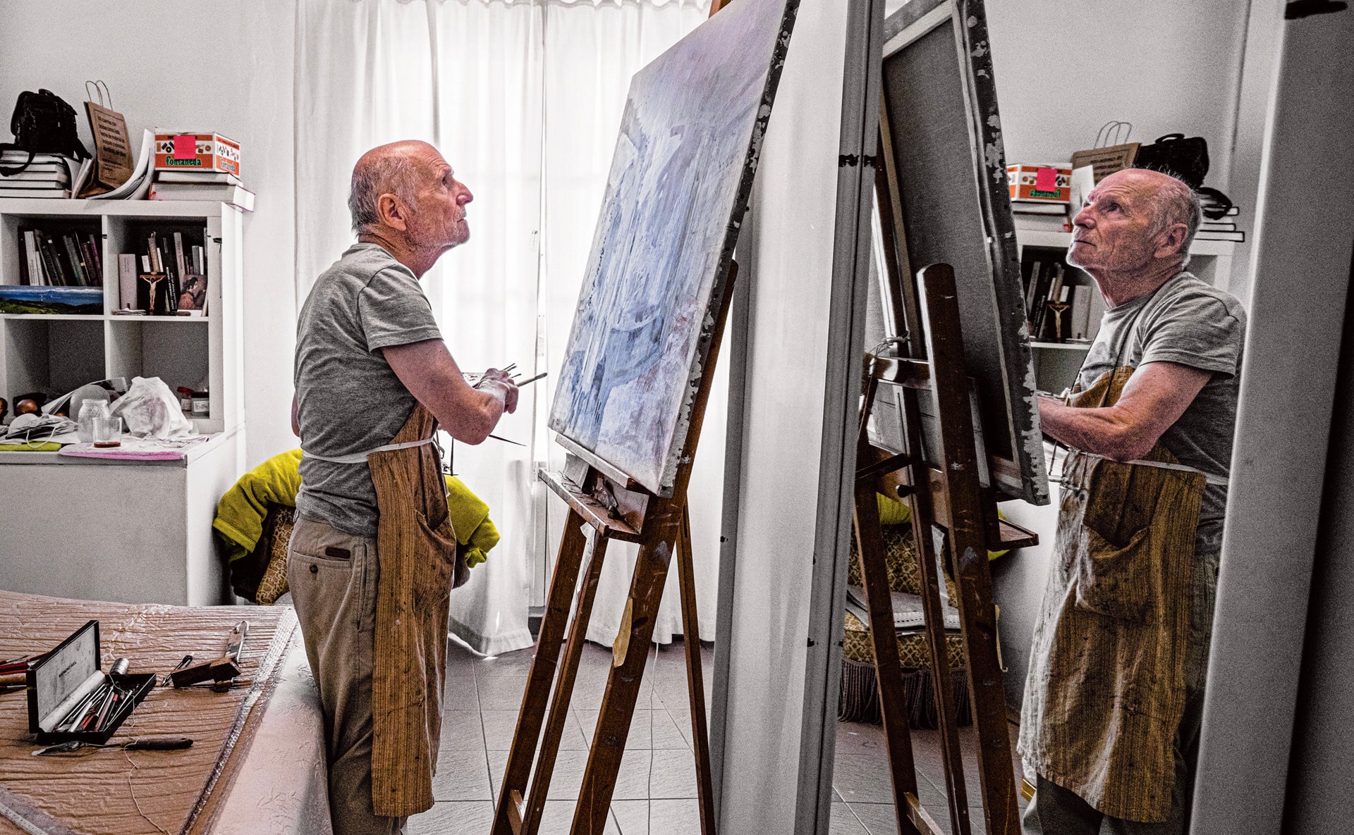 Antonio López pintando un cuadro junto a la cama de una de las habitaciones de su estudio. «Llevo pintando las cosas de mi entorno toda la vida. Es una necesidad».