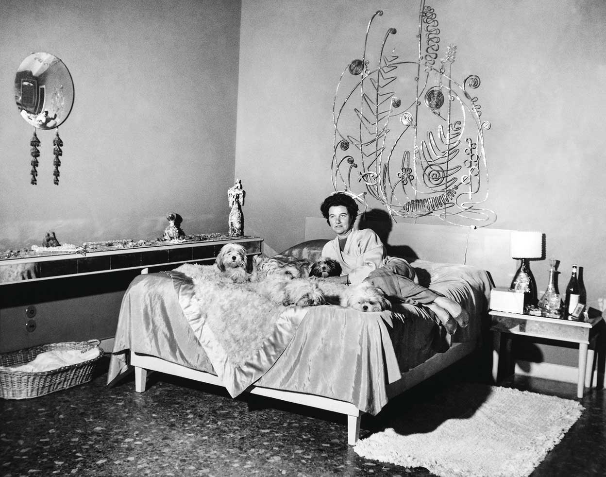 En el jardín de su palazzo veneciano hay un cementerio para «mis amados niños» (sus perros), mientras que su relación con sus hijos fue difícil. Aquí, con ‘sus niños’ y su cabecero de Calder.