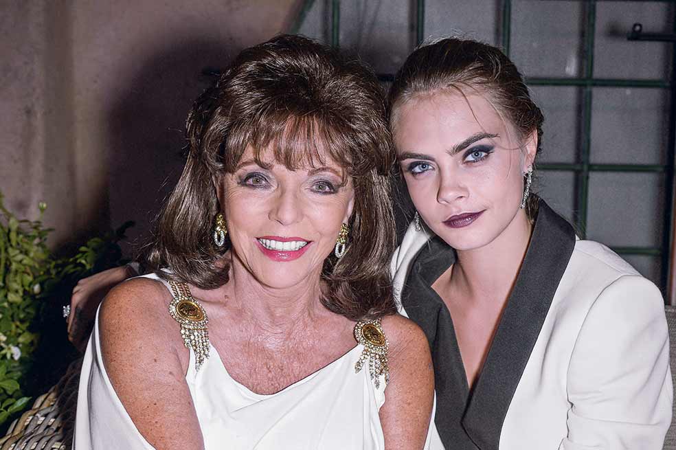 La modelo es su ahijada y siempre habla bien de ella. A lo sumo, describe excesos en su vida, pero no como recriminación. Cuenta que en la fiesta para celebrar los 5 años de Cara, el dueño de la casa, en St. Tropez, «empezó a sacar botellas gigantes de Dom Perignon y rociar con ellas la terraza». Delevingne proviene de la alta sociedad británica. Su abuelo era Sir Jocelyn Stevens, prestigioso ejecutivo de medios de comunicación que se casó con Emma Cheape, prima de la Reina madre. El padre de Cara, Charles, es un magnate del sector inmobiliario; su madre, Pandora, una ex modelo y 'socialite', amiga de Joan de toda la vida.