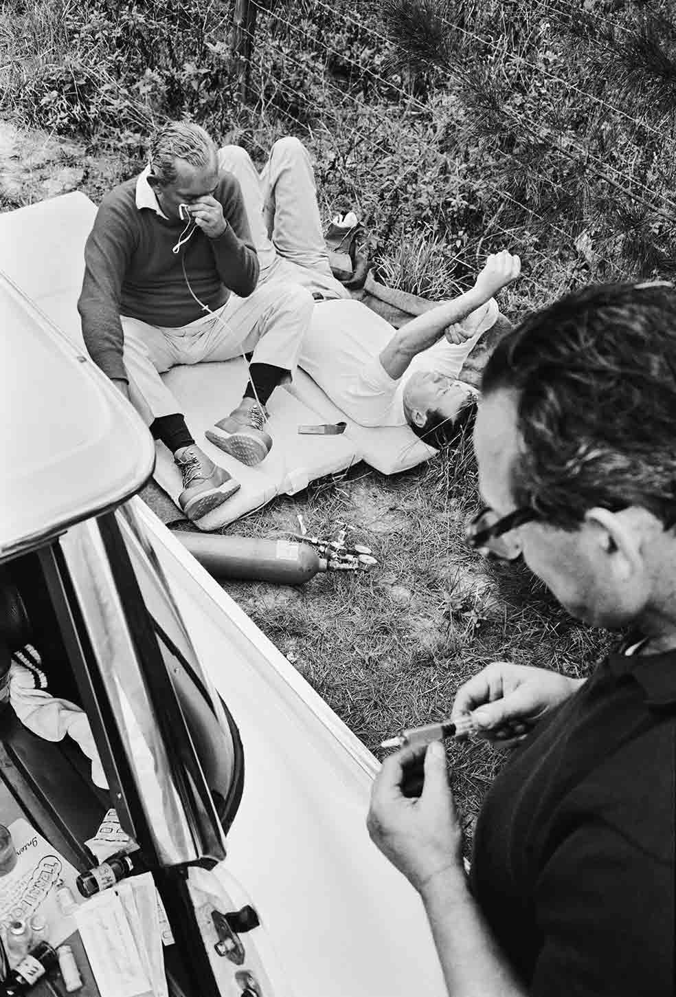 Spalding (tumbado) fue compañero de habitación de Kennedy en Harvard y le presentó a Jacobson (con la jeringuilla), que lo asiste a él y a Radziwill después de una travesía de 80 kilómetros por el campo en Miami en 1963.