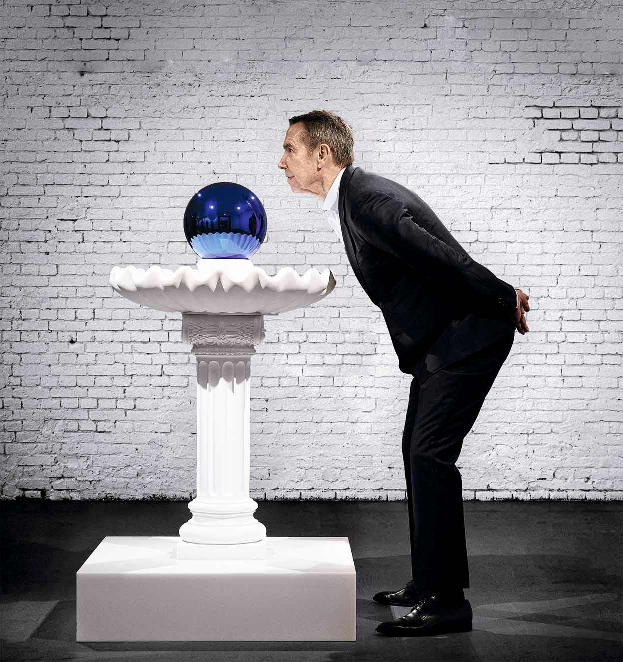 Koons protagoniza ahora una exposición en Florencia y otra en Catar. Tiene galería propia en Nueva York, Pace, después de romper su relación con la Gagosian en 2020. En la imagen posa con su obra Gazing ball, bird bath, de la serie de sus bolas azules sobre esculturas de escayola blanca.