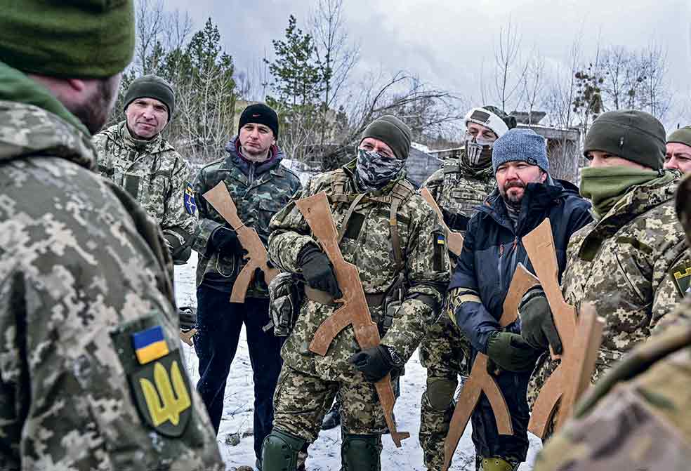 Un grupo de voluntarios se entrena con armas de madera en un bosque a las afueras de Kiev. Son parte de los miles de reservistas ucranianos que han respondido al llamamiento del presidente Volodímir Zelenski para prepararse ante una posible invasión rusa.