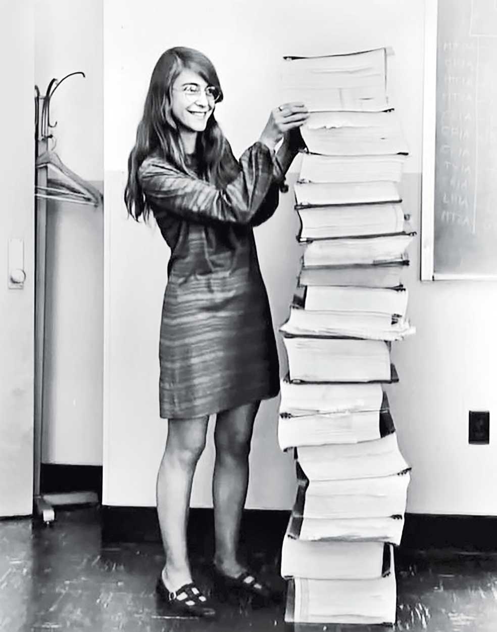 Margaret, en 1969, sonríe con la inseguridad de una estudiante mientras posa junto al 'software' del programa espacial.