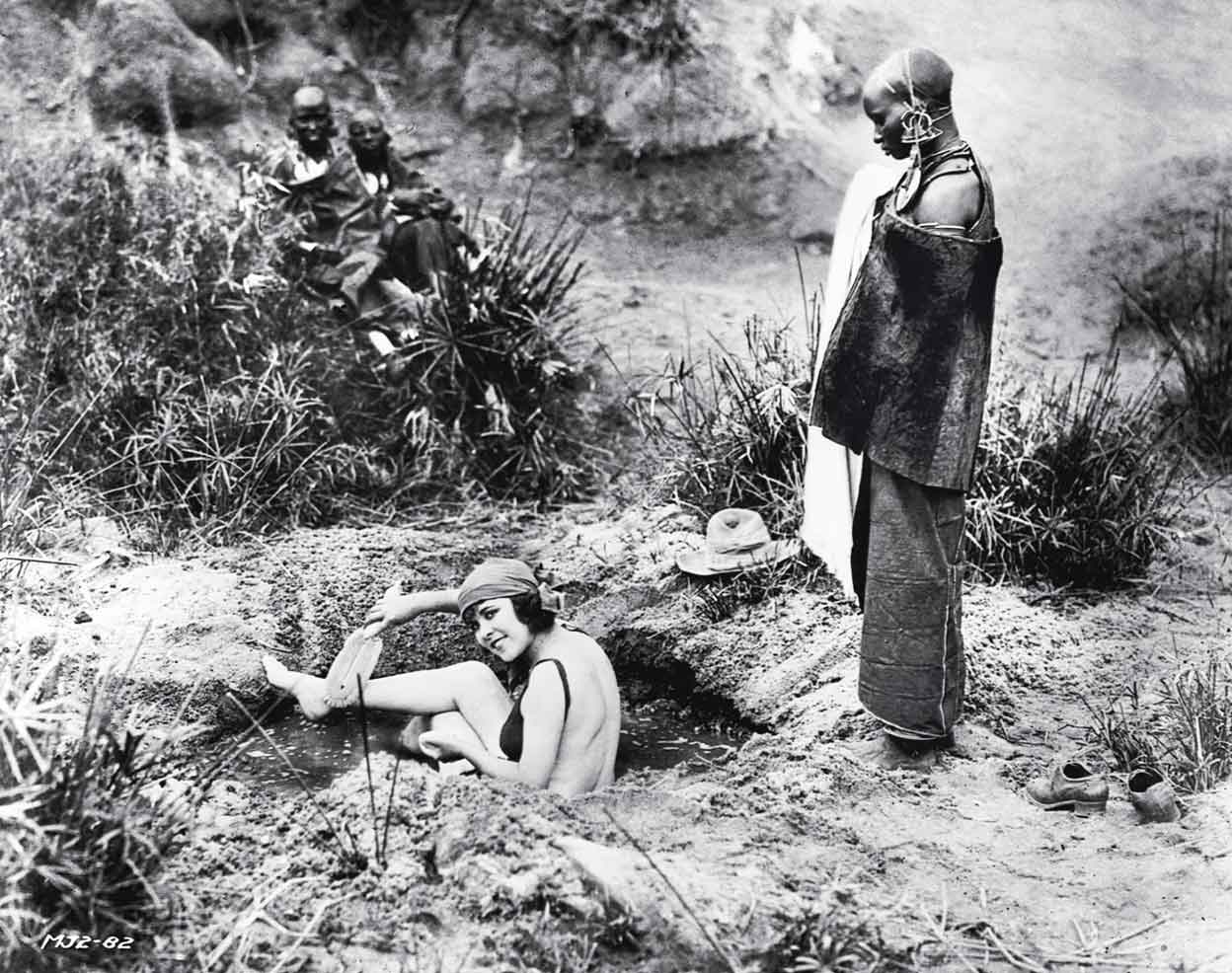 Mujeres lumbwas observan a Osa en una improvisada bañera cerca del lago Paraíso en 1923. Allí rodarían durante cuatro años. Osa posaba así de 'frívola', pero era la más intrépida del equipo. De hecho, tenía mejor puntería que Martin, por lo que se encargaba de cazar y proteger a su marido durante los rodajes.