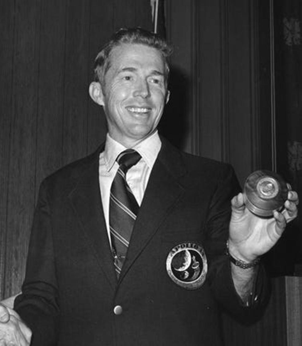 Stuart Roosa sostiene el bote que contiene las semillas de árbol que orbitaron 34 veces las Luna en 1971. |