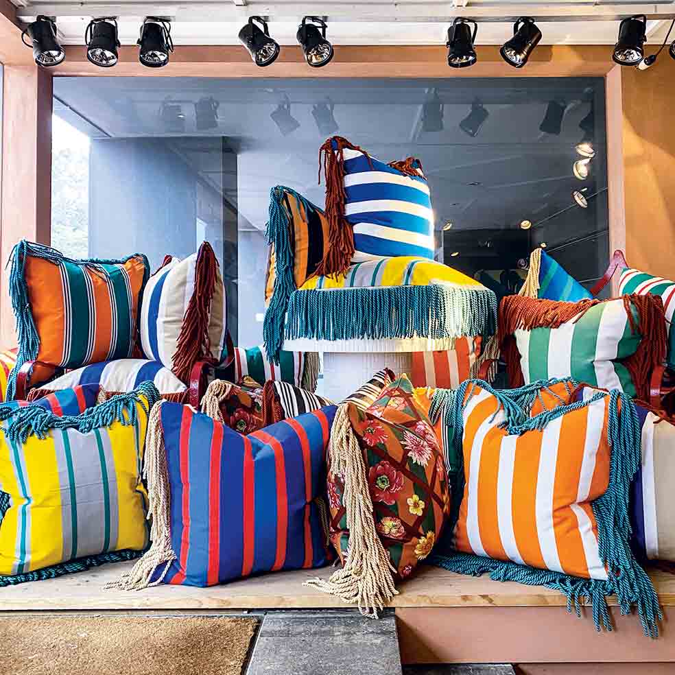 Lo exclama Demeyer para invitar a la gente a rodearse de colores vivos. Para crear estos cojines de exterior compró las telas y borlas en un telar belga que cerraba.