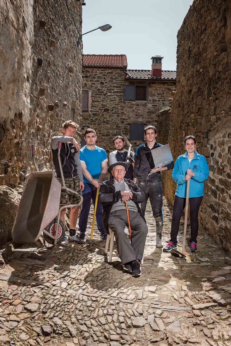 Priscilo Ramos, de 94 años, es el más veterano de los que emigraron. Ahora, los jóvenes colaboran para darle nueva vida a Sarnago. De derecha a izquierda: Andrea (investigadora), Marcos (arquitecto), Mikel (ingeniero), Imanol (diseñador web) y Alejandro (estudiante).
