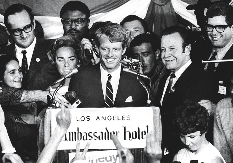 Imagen principal - Otro asesinato en directo. Noguchi había realizado la autopsia de Marilyn seis años antes y esta vez tenía sobre la mesa el cuerpo de su supuesto amante, Robert F. Kennedy. En las fotos, su última aparición (1) antes de que le disparasen (2). El impacto de la bala tras la oreja (3) fue letal: el cabello se lo habían rasurado en el preoperatorio para intentar salvarlo.