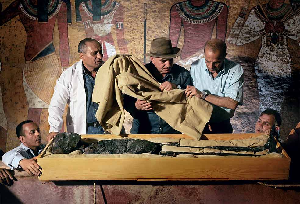 Hawass con la momia de Tutankamón en el interior de su tumba en el valle de los Reyes, la necrópolis de los faraones en Luxor. Como arqueólogo, Hawass puede atribuirse logros históricos como el hallazgo de las tumbas de los constructores de las pirámides en 1990 en Giza y su larga investigación de ello junto con el arqueólogo Mark Lehner; el descubrimiento del valle de las Momias Doradas en 1996, más de tres mil sarcófagos de hace dos mil años; o la identificación de la momia de Hatshepsut, la reina faraón, en 2007.