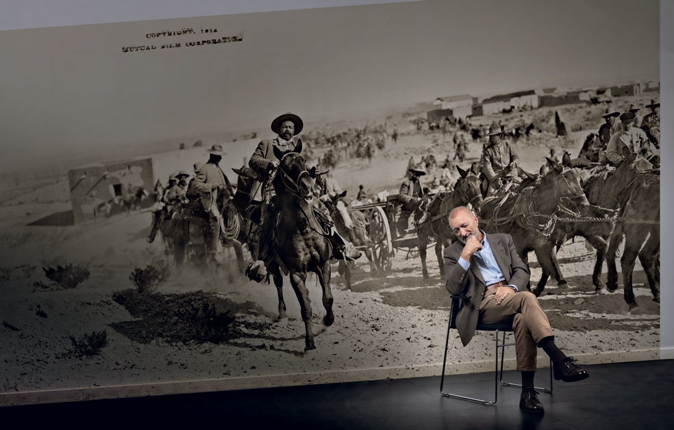 En la imagen, detrás del escritor, una fotografía de Pancho Villa en tiempos de la Revolución mexicana. «Su figura la trabajé mucho porque me interesaba el personaje en sí mismo». La nueva novela de Pérez-Reverte estará ya a la venta en las librerías el próximo 3 de octubre, publicada por Alfaguara. En la foto superior, el escritor delante de un detalle del mural Historia de México, de Diego Rivera |