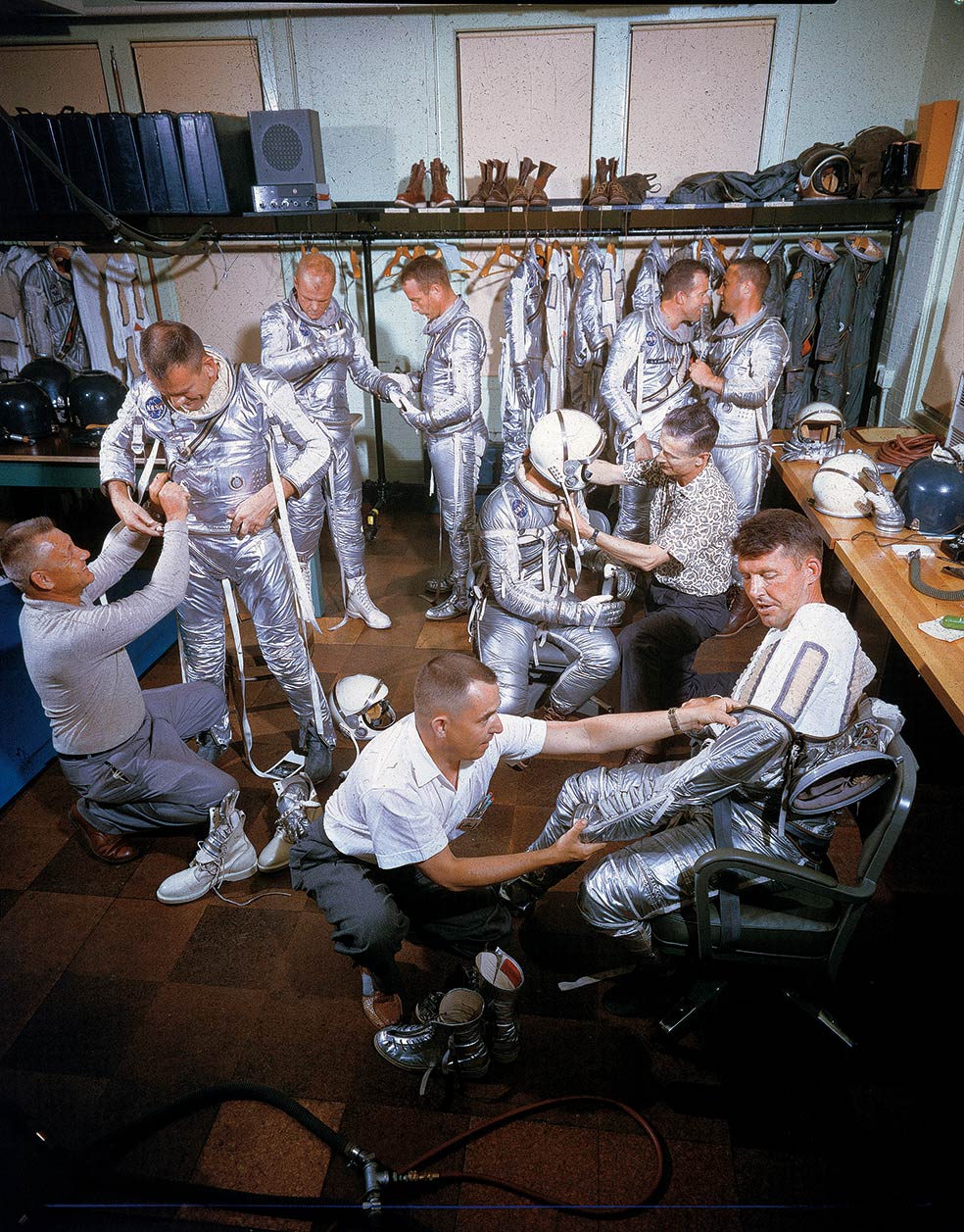 Tres técnicos visten a los miembros del primer proyecto de la NASA: Deke Slayton, John H. Glenn Jr., Scott Carpenter, Gordon Cooper, Gus Grissom, Alan B. Shepard Jr. y Wally Schirra Jr.