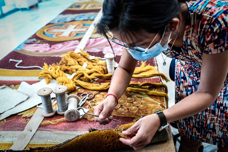 Un empleado trabaja en la restauración de la alfombra del coro de Notre-Dame de París. Aunque hay propuestas para introducir arte contemporáneo en el interior de la catedral, la principal misión sigue siendo recuperar el valor cultural que ya tenía antes del incendio.