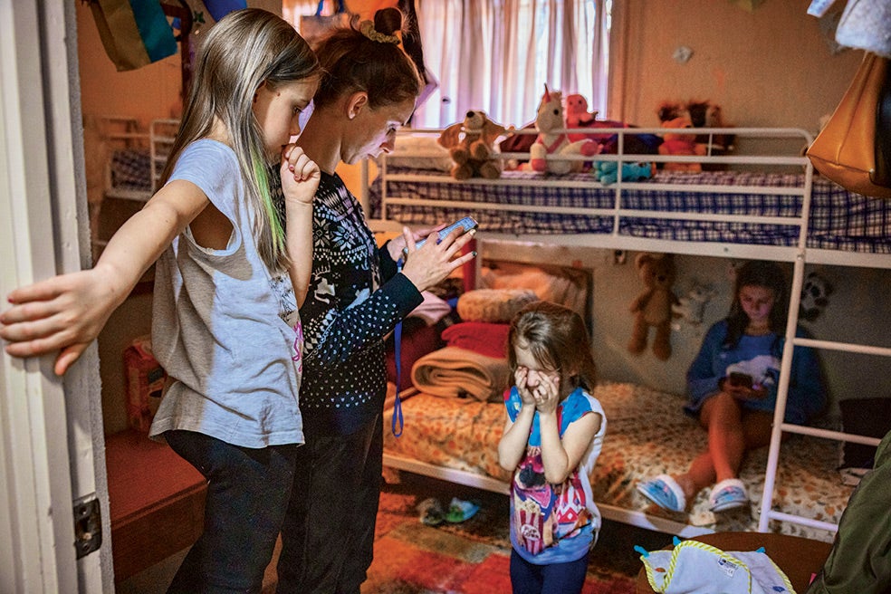 La hija de 14 años cuenta que ha sufrido el rechazo de algunos compañeros en el colegio. Olesia, la madre, vive pegada al teléfono, pendiente de los bombardeos en Ucrania, donde se ha quedado su marido luchando. Tiene, además, a su padre enfermo. Aquí, en su habitación de la residencia de acogida.