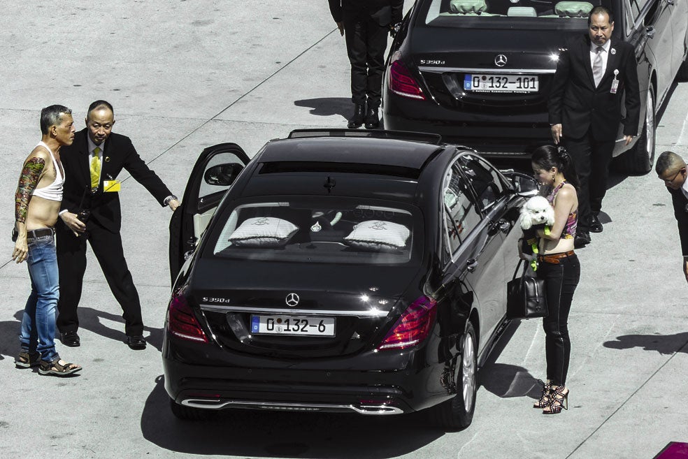 En la imagen, el rey con uno de los tops que acostumbra a lucir y tatuajes de hena. A la derecha, una de sus concubinas con Foo Foo, el caniche con el título de mariscal del Ejército del Aire.