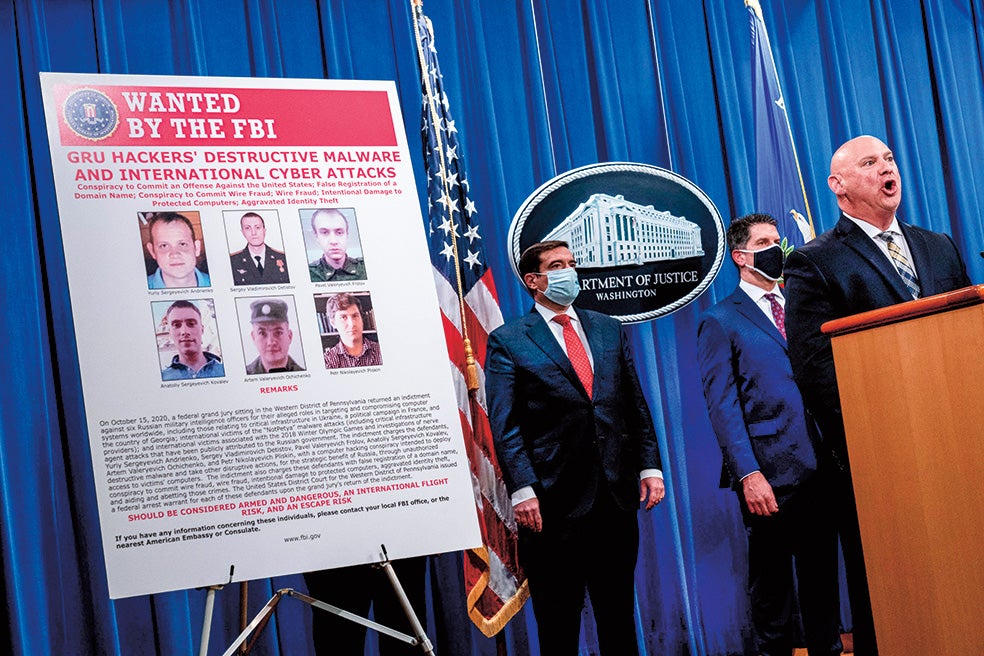 Agentes del FBI muestran en 2020 el cartel con seis oficiales de inteligencia militar rusos acusados de llevar a cabo ataques cibernéticos en la red eléctrica de Ucrania, las elecciones francesas de 2017 y los Juegos Olímpicos de Invierno de 2018.