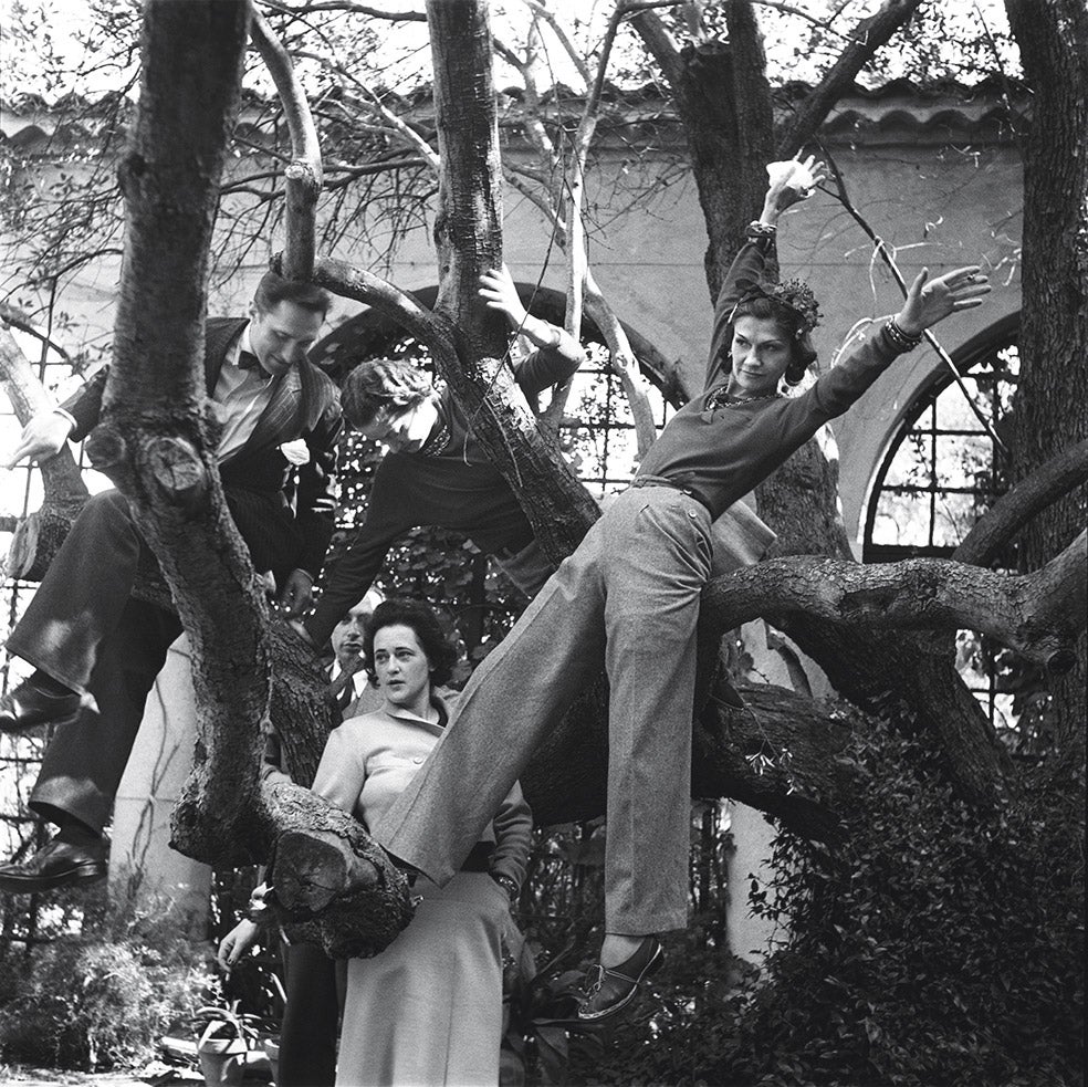 Coco, en pantalones, en 1938, con amigos en su finca cerca de Cannes. Chanel liberó a las mujeres de los sombreros emplumados, el corsé, el cabello largo... Una revolución que aún perdura.