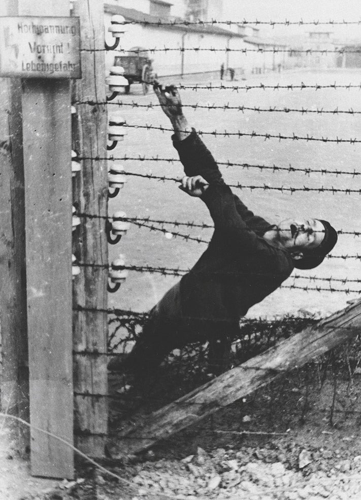 Tres suboficiales de las SS tomaban imágenes del campo. Un grupo de prisioneros, entre los que había españoles, debía revelar aquellas fotos. Lograron sacar de allí miles de imágenes como esta de un recluso electrocutado en una de las alambradas del campo.