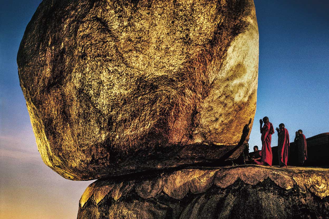 Según un mito, esta mole de granito desafía la gravedad porque está apoyada sobre un cabello de Buda. Encima de ella, se alza un pequeño templo. Es uno de los centros de peregrinación budistas más importantes. «Asia está plagada de culturas milenarias que conviven muy cerca unas de otras –dice McCurry –. Es un lugar único». Imagen de la Pagoda Kyaiktiyo, tomada en 1994.