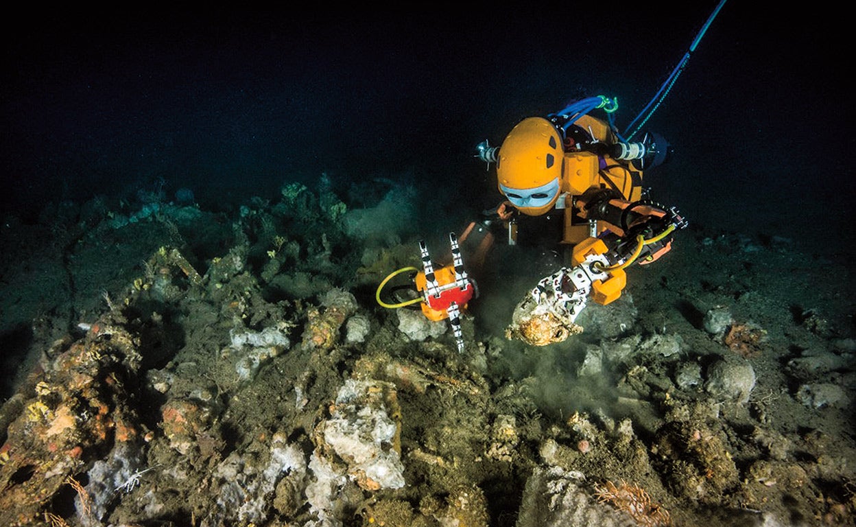 Un robot buzo humanoide, desarrollado en la Universidad de Stanford, en plena tarea de rastreo y rescate de objetos de posible valor. Más arriba, en la imagen que abre este reportaje, uno de los barcos de Ocean Infinity preparados para operar no tripulados, sin humanos a bordo.