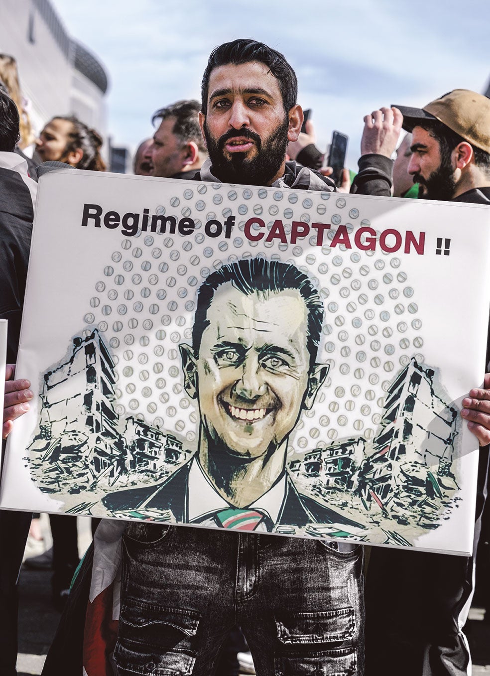 Manifestantes en Bélgica acusando al presidente sirio de beneficiarse del tráfico de captagon.