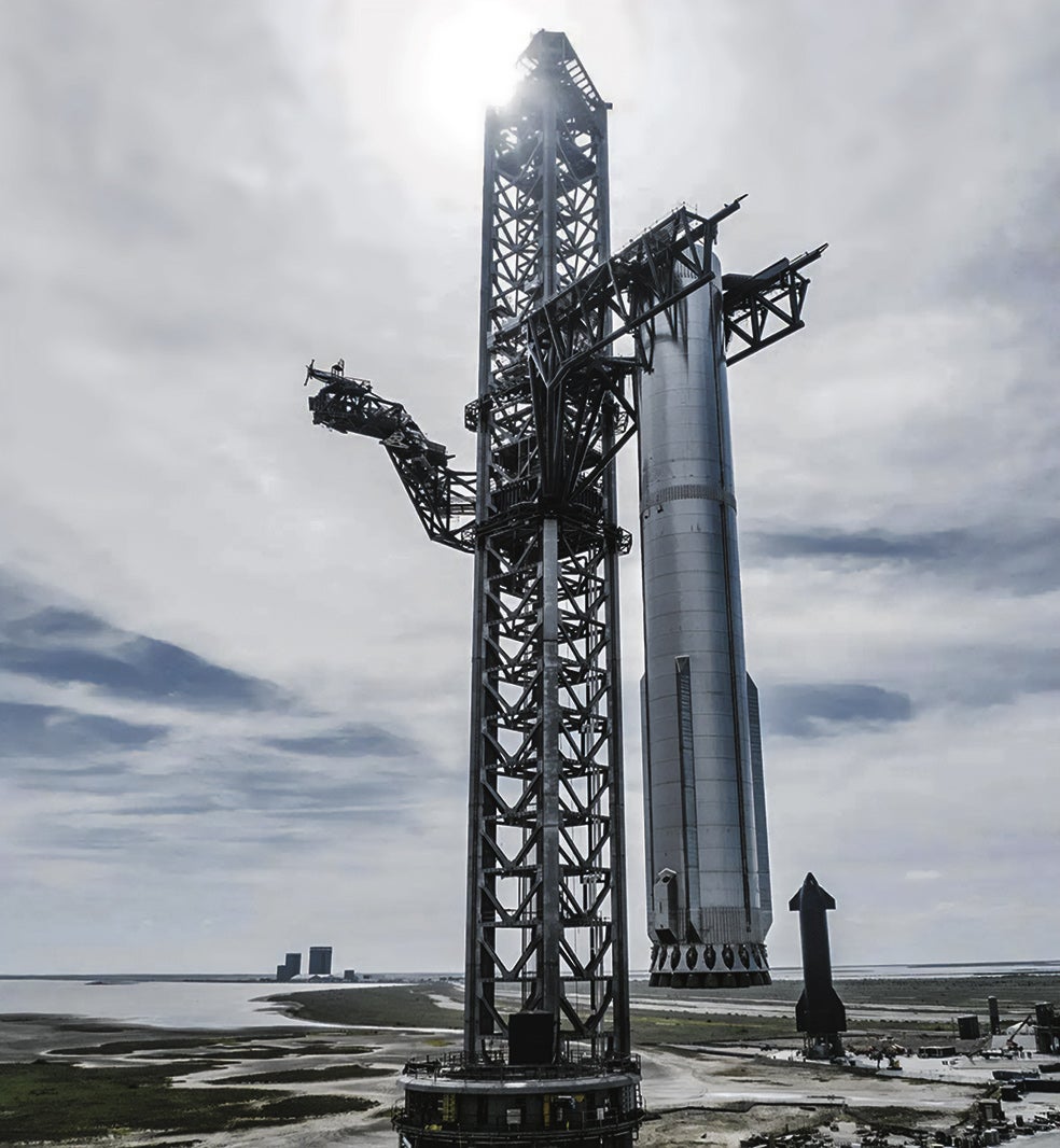 El Starship se divide en dos partes: el cohete propulsor y la nave. El propulsor, en la foto, cae o desciende poco después de impulsar a la nave. Para evitar que colisione en el suelo, SpaceX ha desarrollado un brazo robótico que lo captura al vuelo, como se ve en la imagen.