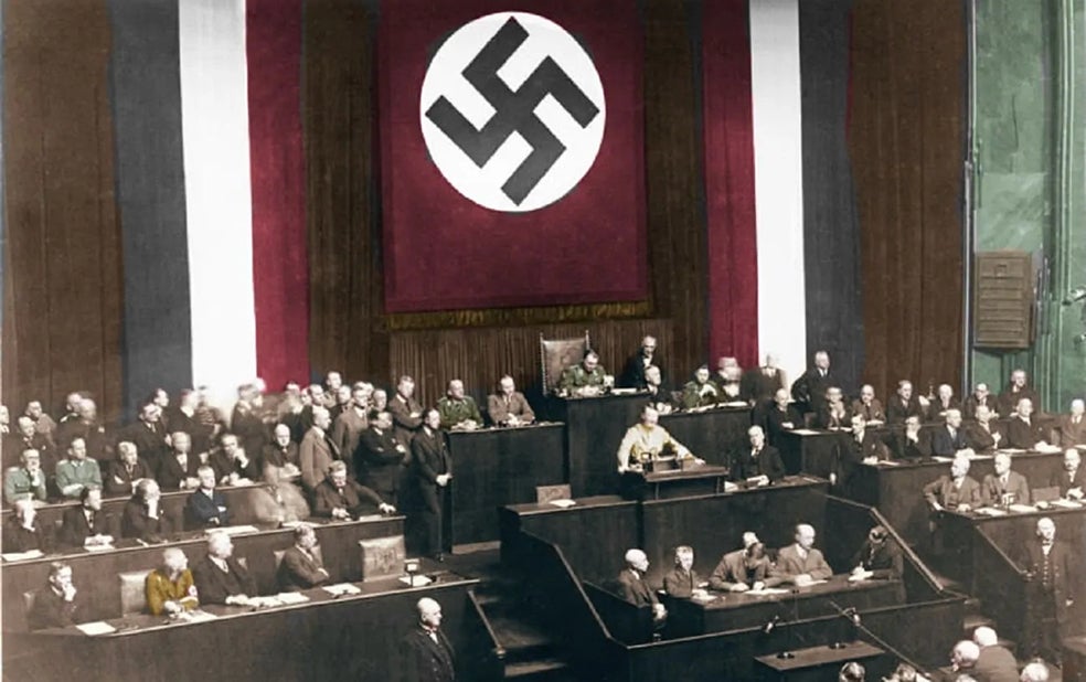 Hitler habla en 1934 en el Reichstag, el Parlamento alemán, el día en que se aprobó la ley habilitante que acabó con la democracia. El Parlamento estaba instalado en la sede de la Opera tras un incendio en el edificio del Reichstag en febrero de 1933, cuyo origen (los nazis acusaron a los comunistas de provocarlo) todavía sigue siendo objeto de debate.