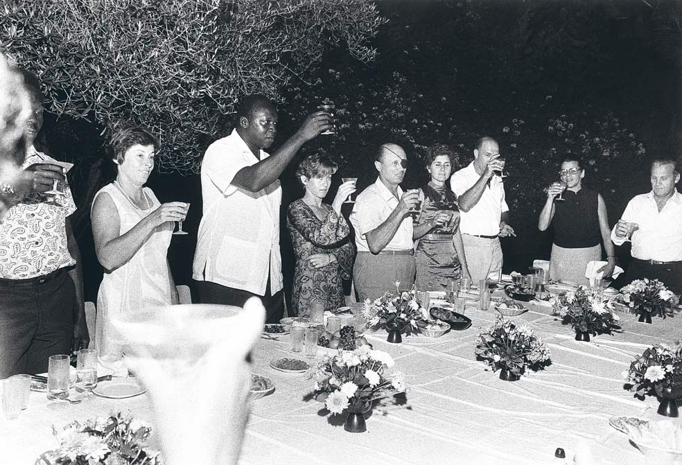 Amin brinda con sus invitados, en este caso el ministro de Defensa israelí y otros militares. Pese a ser musulmán, Amin bebía y comía de todo, incluso carne de cerdo.