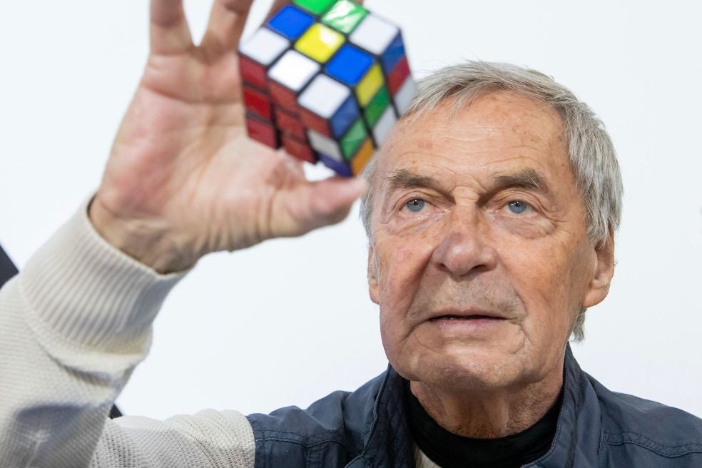 Ernö Rubik era profesor de la Escuela de Artes Comerciales de Budapest en los años setenta cuando ideó su primer cubo. Poco después de que se popularizase su invento, Rubik abrió su propio estudio de diseño y hoy en día, con 80 años, sigue ejerciendo de inventor, arquitecto, diseñador, editor y escritor.