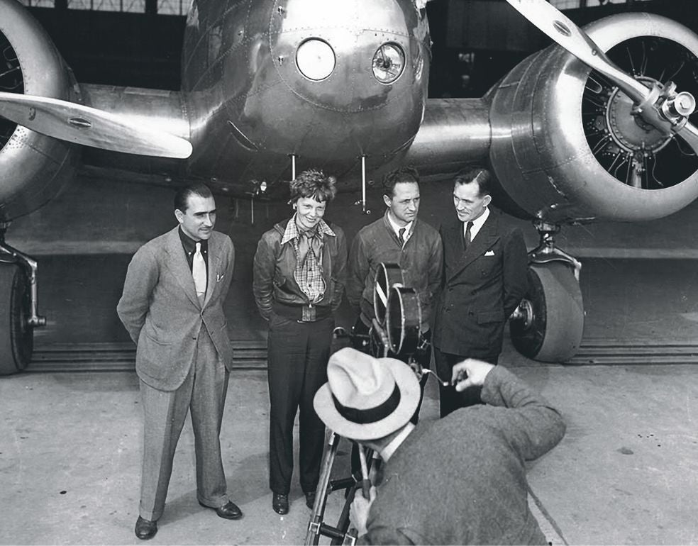 Earhart con el equipo inicial de su intento de vuelta al mundo en 1937, delante del avión Electra. Tras sufrir un accidente en Honolulu que retrasó la misión, solo el navegante Fred Noonan (a la derecha) —alcohólico reconocido— aceptó acompañarla. El 2 de julio de 1937, ambos desaparecieron en el Pacífico.